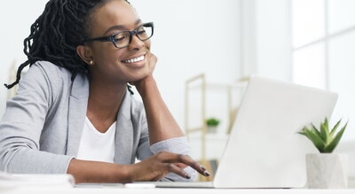 businesswoman looking at the screen smiling, positive customer experience